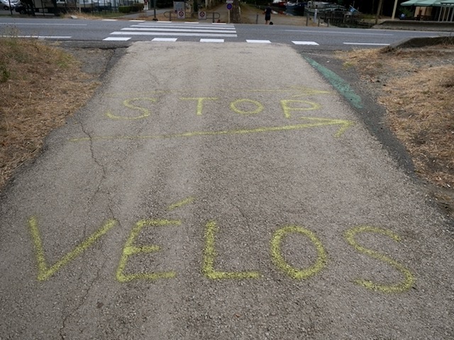 Stop pour les vélos écrit sur la piste cyclable